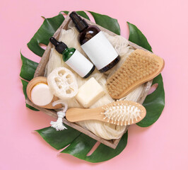 Tray of Cosmetics, skin and hair care accessories on tropical leaves on pink, mockup