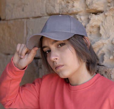 Teenager girl in grey baseball cap and long sleeve shirt outdoor, mockup