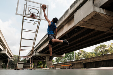 Two caucasian men pratice baskegball in court at urban street.