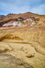 Obraz premium Desert creek dried up next to colorful mountains