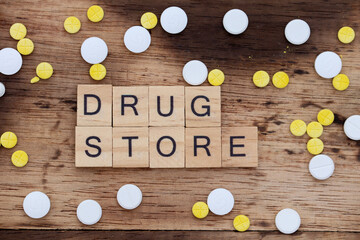 wooden block with the word drug store written on it with a wooden backdrop and medicine
