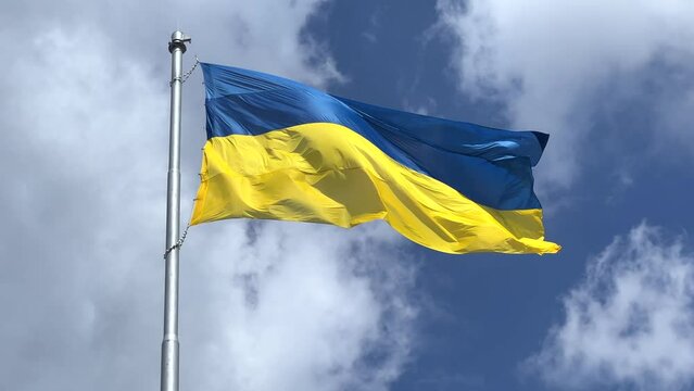 The flag of Ukraine is a great national symbol fluttering in the blue sky. Big yellow and blue Ukrainian state flag, Kyiv, Independence Constitution Day, National holiday.