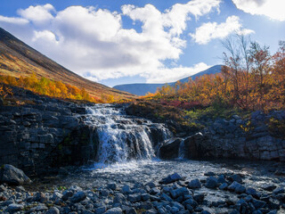 Beautiful mountain waterfall among rocks in polar summer in Khibiny Mountains. Kola Peninsula, Arctic, polar summer