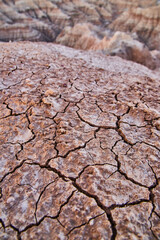 Badlands cracks in ground with canyons in distance