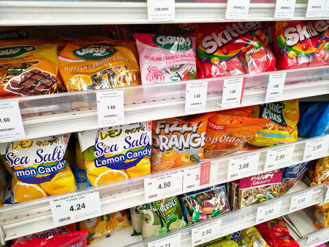 SELANGOR, MALAYSIA -MAY 13, 2022: The candies are wrapped in commercial plastic packaging and labelled by brand. Display on a supermarket shelf for sale. Every item has a different price tag. 