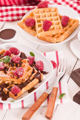 Waffles with raspberries and chocolate cream.
