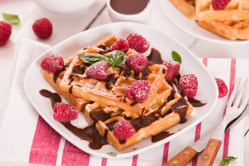 Waffles with raspberries and chocolate cream.