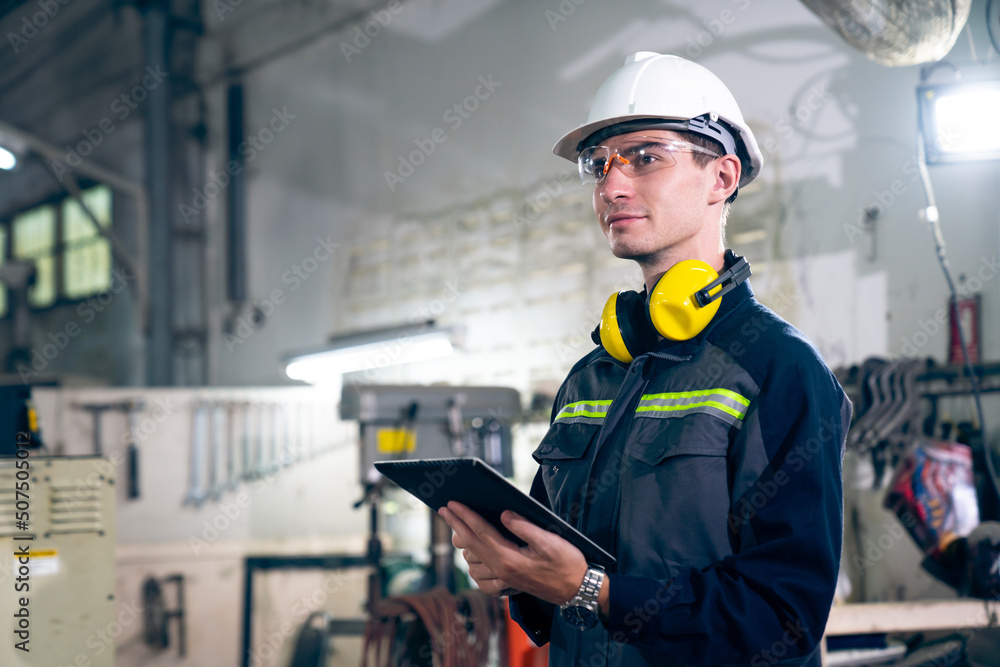 Poster young factory worker using adept tablet computer in a workshop building . industrial technology and 