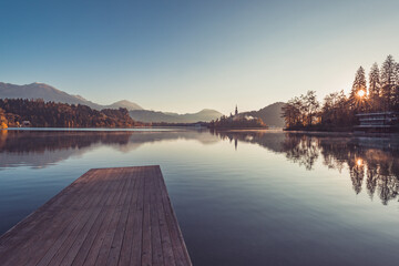 Wooden pier at lake Bled in the early morning. Beautiful and calm destination for a morning walk.