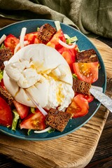 Tomato salad with toasted bread, onion and italian buratta