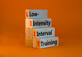 LIIT low-intensity interval training symbol. Concept words LIIT low-intensity interval training on blocks on a beautiful orange background. LIIT low-intensity interval training concept. Copy space.