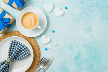 Table setting for Father's day breakfast with coffee cup, plate  and gift box on modern background....