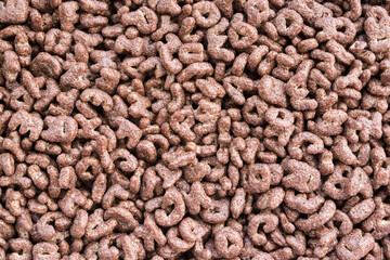 Cereal. Chocolate flakes in the form of letters. Background texture of dry breakfast. Texture.