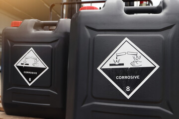 Corrosive chemical symbols on a black chemical tank