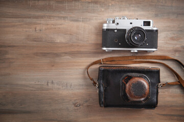 Old retro camera on wooden background.