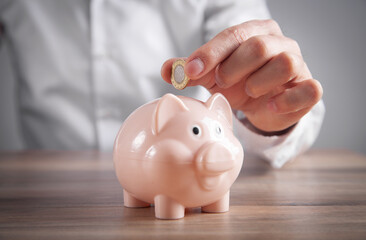 Man putting coin to piggy bank. Saving