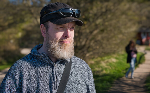 Typisch norddeutsch: b&auml;rtiger Friese mit M&uuml;tze, Pullover und Sonnenbrille im friesischen Sommer