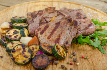 Grilled barbecue steaks on wooden board