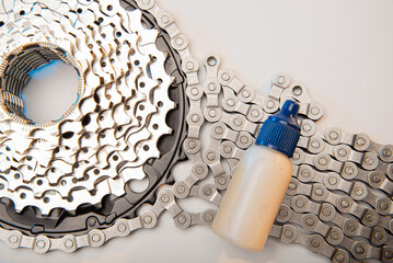 Oiling the bicycle chain with an oiler. Care of the bicycle's drive system. Dark background.