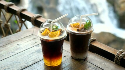 Refreshment drinks in plastic cups with straws for takeaway. Iced orange coffee and chocolate cocoa...
