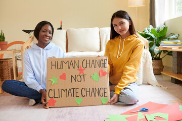 Smiling activists showing placard they made for climate change event in college
