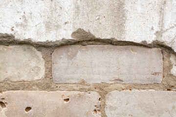The texture (background) of the destroyed cement old wall (plaster, concrete) from under which the brickwork is visible.