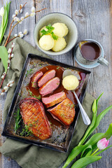 Traditionell gegrilltes Gourmet Entenbrust Filet mit Haut serviert mit Kartoffelknödeln in Dunkelbier Sauce als Draufsicht auf einem rustikalen Metalltablett