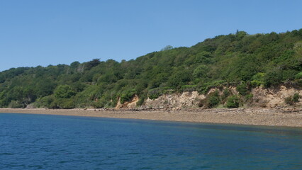 Sortie en bateau voilier - vue sur la côte avec de la nature, de la roche, du sable et de la mer, près de la rade de Brest, plage et forêt à proximité, région bretonne