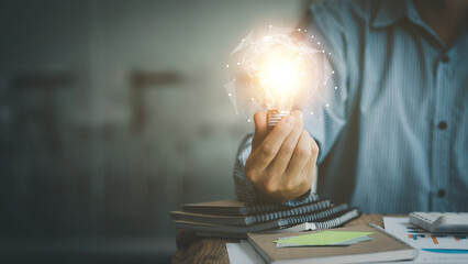 Standing man hold glowing light bulb, Creative new idea. Innovation, brainstorming, strategizing to...
