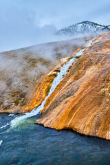 Alkaline waterfall merging into clean river water in Yellowstone