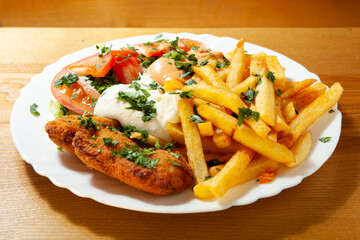 Hähnchenschnitzel mit Pommes auf dem Teller