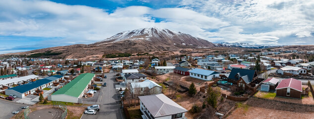 Aerial scenic view of the historic town of Husavik on a beautiful day with blue sky and clouds, north coast of Iceland