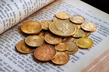 Goldmünzen in einem alten aufgeschlagenen Buch