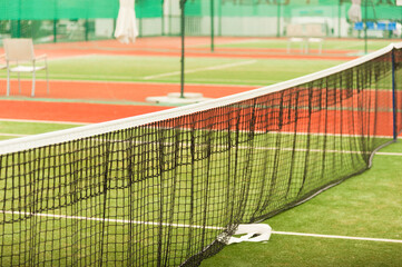 Fototapeta premium Tennis net on an empty tennis court. Horizontal frame with copy space