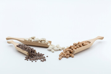 three wooden pallets with different legumes on a white background