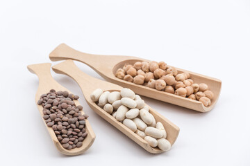 three wooden pallets with different legumes on a white background