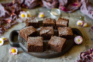 Dessert for the whole family: chocolate brownie on a black plate on a gray background. Chocolate cakes for breakfast Close-up