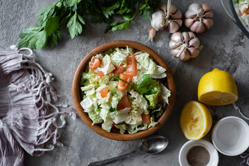 Vegetarian lunch. Salad of fresh vegetables: cabbage, tomatoes, onions, parsley, cucumbers in a...