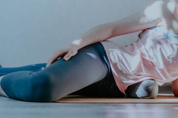 Woman doing visceral self myofascial release on soft grey ball. Concept: self care practices at home, SFMR, MyoYin	