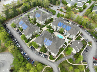 aerial view of apartment buildings with solar panel installed on roof in spring