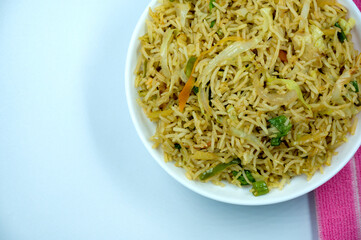 Indian vegetarian pulao or Veg fried rice or Veg Briyabi in brown decorated white bowl with isolated white background. Veg Schezwan Fried Rice ,Vegetarian Szechuan Rice isolated.