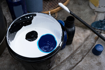 Mixing different colors in white paint, a combination of black and blue. Preparation for painting