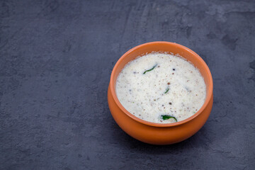 Fresh made Indian food, chutney, Coconut chutney in a bowl with raw coconut. Served with dosa, idli, vadai, Pongal. Selective focused home made coconut chutney in isolated white background.