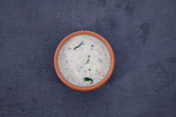 Fresh made Indian food, chutney, Coconut chutney in a bowl with raw coconut. Served with dosa, idli, vadai, Pongal. Selective focused home made coconut chutney in isolated white background.