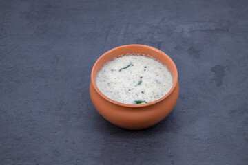 Fresh made Indian food, chutney, Coconut chutney in a bowl with raw coconut. Served with dosa, idli, vadai, Pongal. Selective focused home made coconut chutney in isolated white background.
