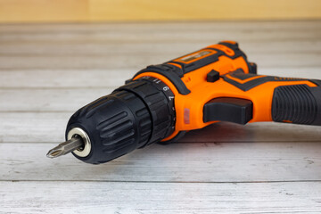 Cordless combo drill for used as normal drill, impact drill on wooden background. Selective focus
