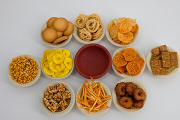 Traditional Indian Diwali salty snacks and sweets, foods items displayed and arranged in bowl on an...