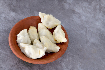 Selective focused Kozhukatta Pidi in mud plate Indian Kerala , Tamilnadu tea time snack steamed food sweet modak rice dumpling for ganesha chathurthi, Diwali, Navratri Dussehra
