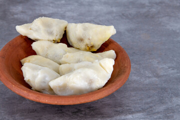 Selective focused Kozhukatta Pidi in mud plate Indian Kerala , Tamilnadu tea time snack steamed food sweet modak rice dumpling for ganesha chathurthi, Diwali, Navratri Dussehra
