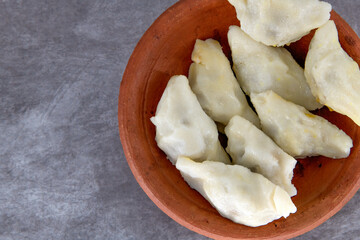 Selective focused Kozhukatta Pidi in mud plate Indian Kerala , Tamilnadu tea time snack steamed food sweet modak rice dumpling for ganesha chathurthi, Diwali, Navratri Dussehra
